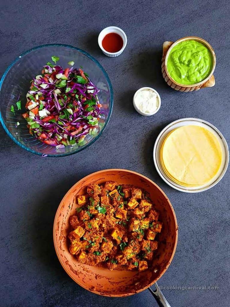 achari paneer, tacos topping and corn tortilla on a gray table