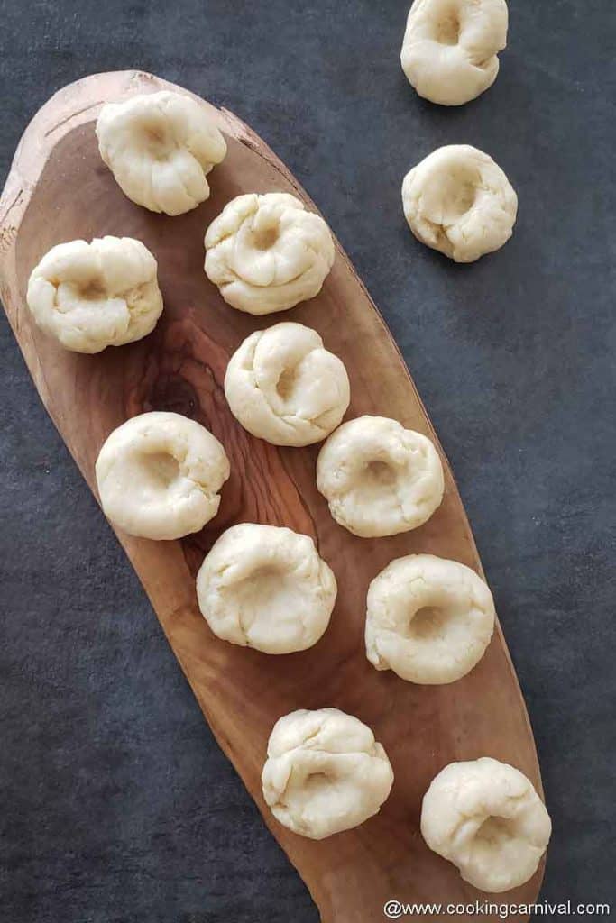 Un-fried balushahi on a wooden board