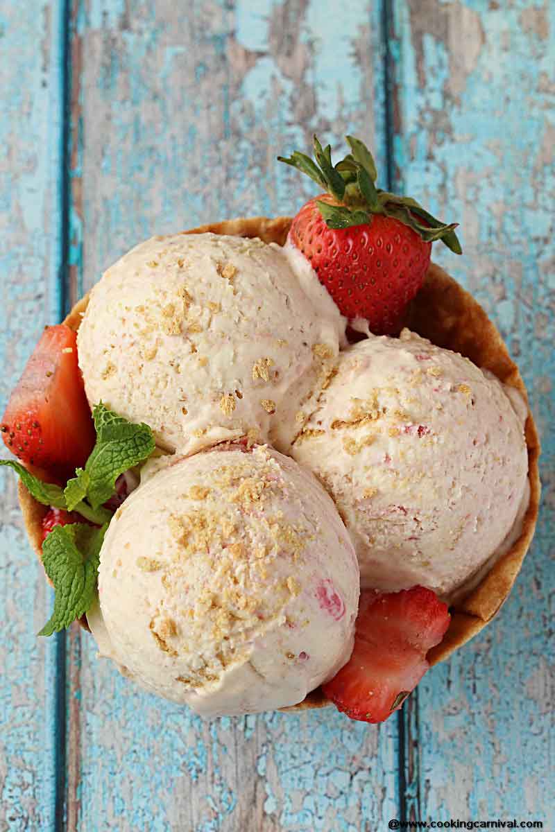 Homemade Strawberry Cheesecake Ice Cream - Creamy Ice cream Base with cream cheese and a Strawberry Sauce and Roughly Crushed Graham crackers swirled throughout. Its Dreamy, Creamy and one of the most delicious Homemade Ice cream I have made!