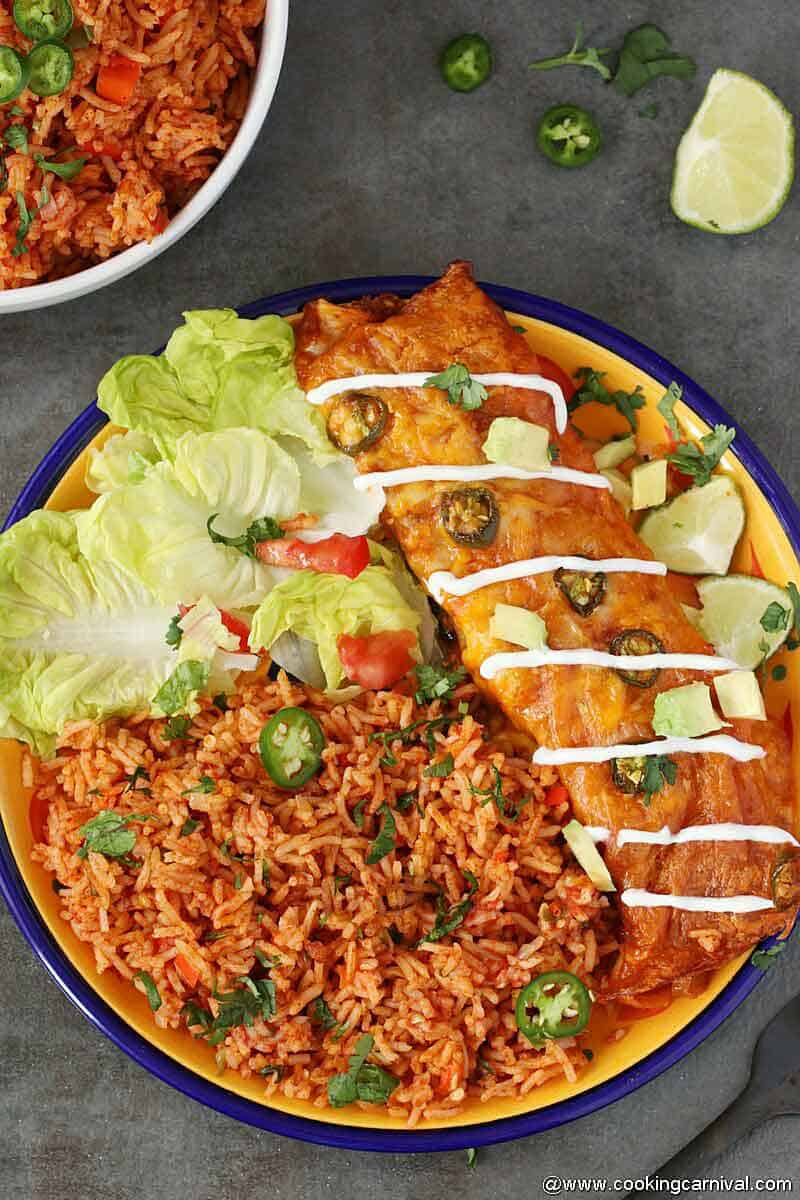 Mexican rice made in instant pot and served in yellow plate with enchilada and salad