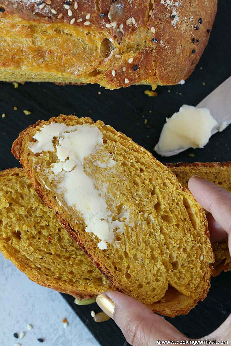 Grabbing a slice of buttered pumpkin no knead butter