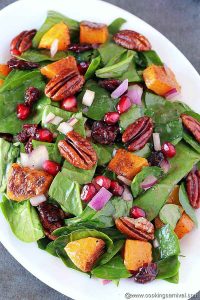 Butternut squash spinach salad on a white plate