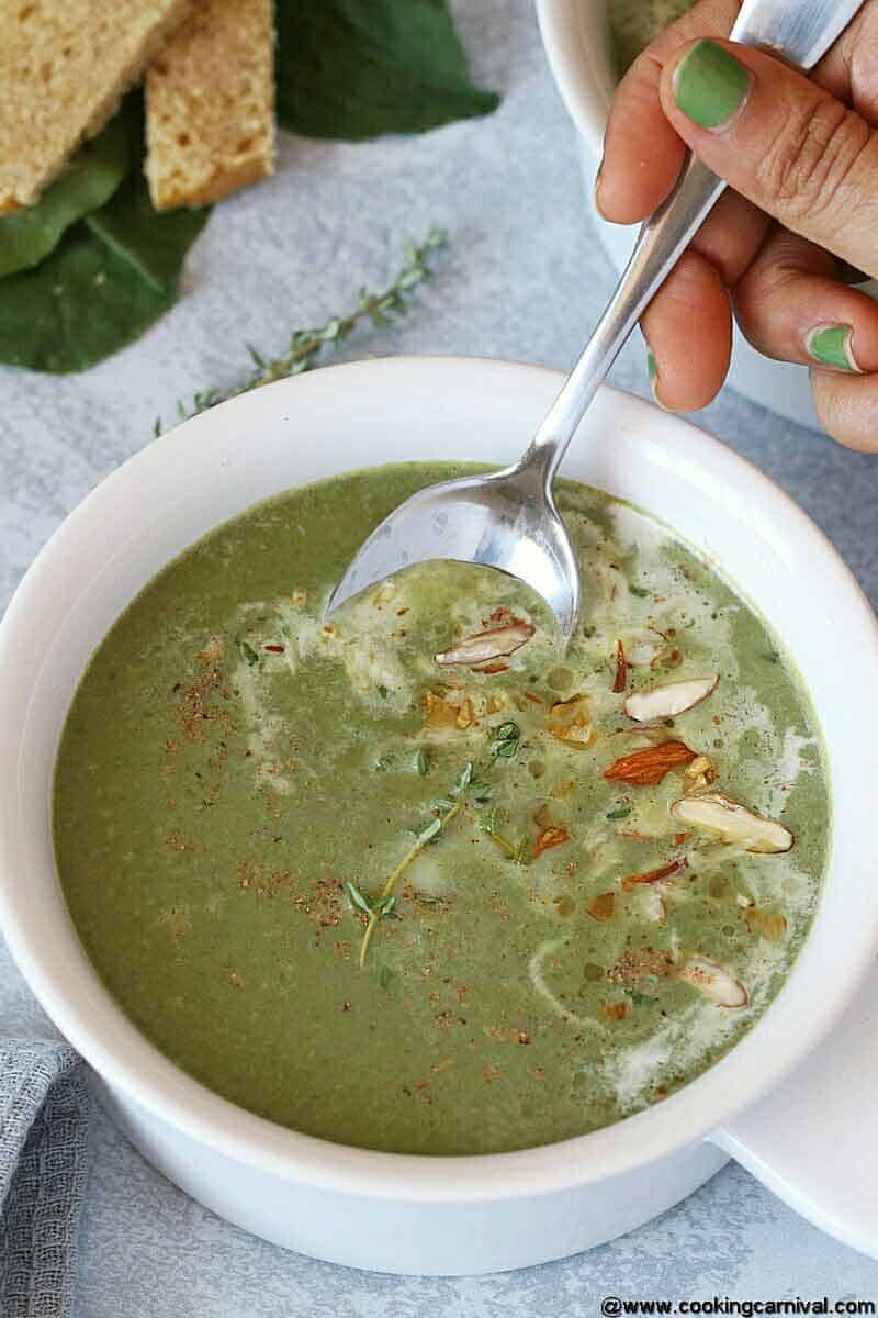 Eating Instant pot green soup with spoon from white bowl