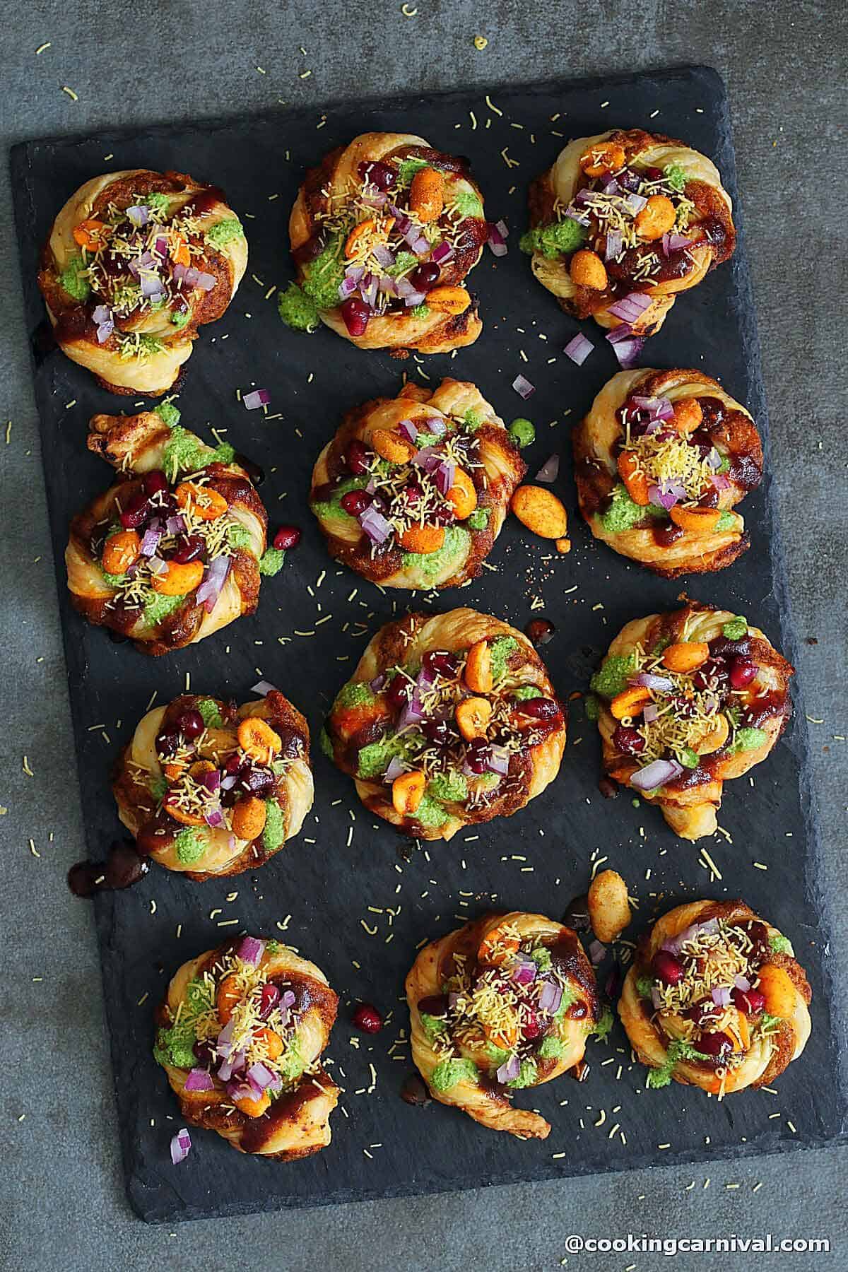 Dabeli puff pastry swirl on a black cheese board.