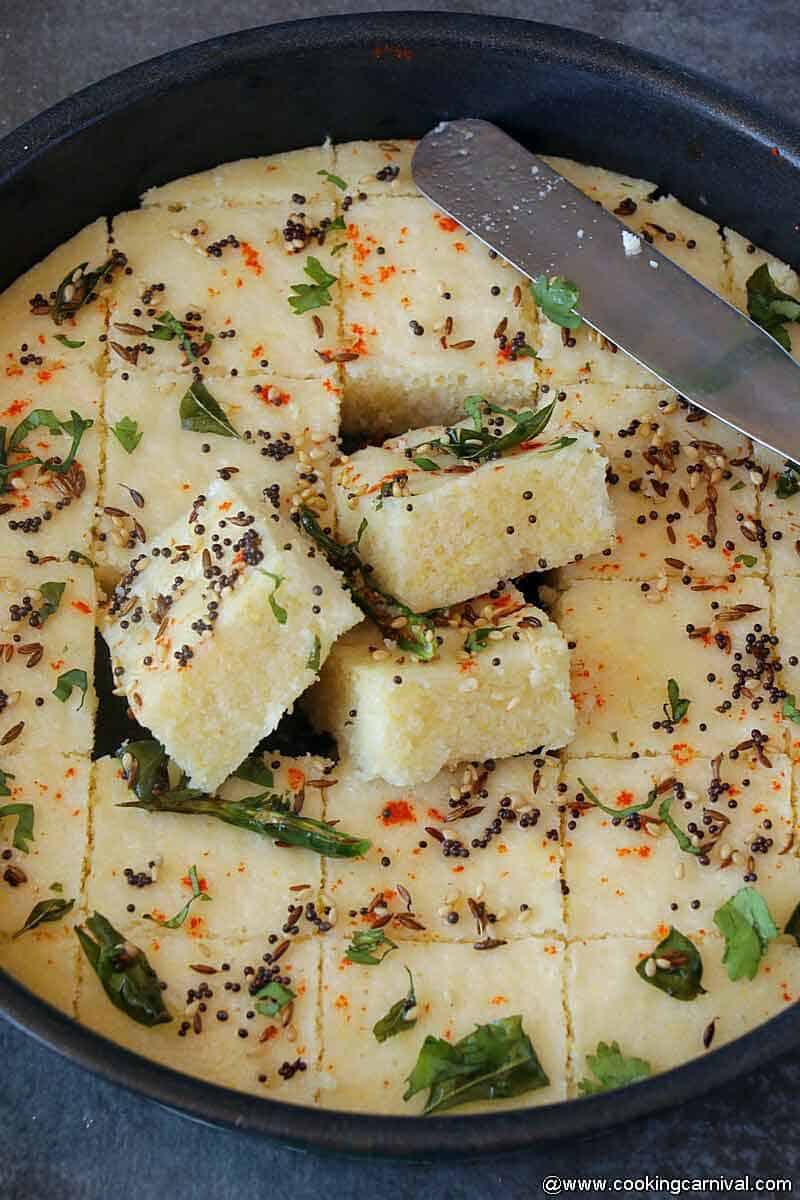 Cut dhokla on a plate with butter knife