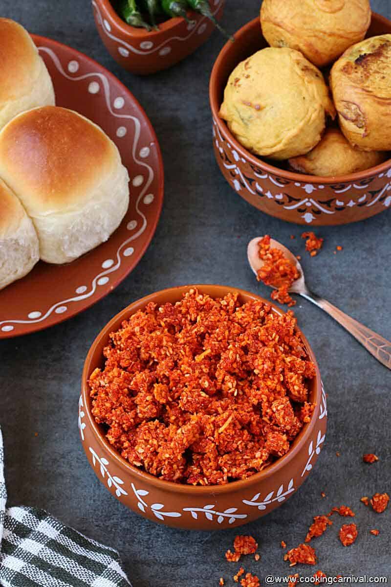 dry garlic chutney served in a traditional ware, pav and vada on the sides