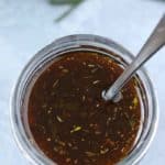 Balsamic Vinaigrette Dressing in a 4 oz mason jar with spoon on a gray tile