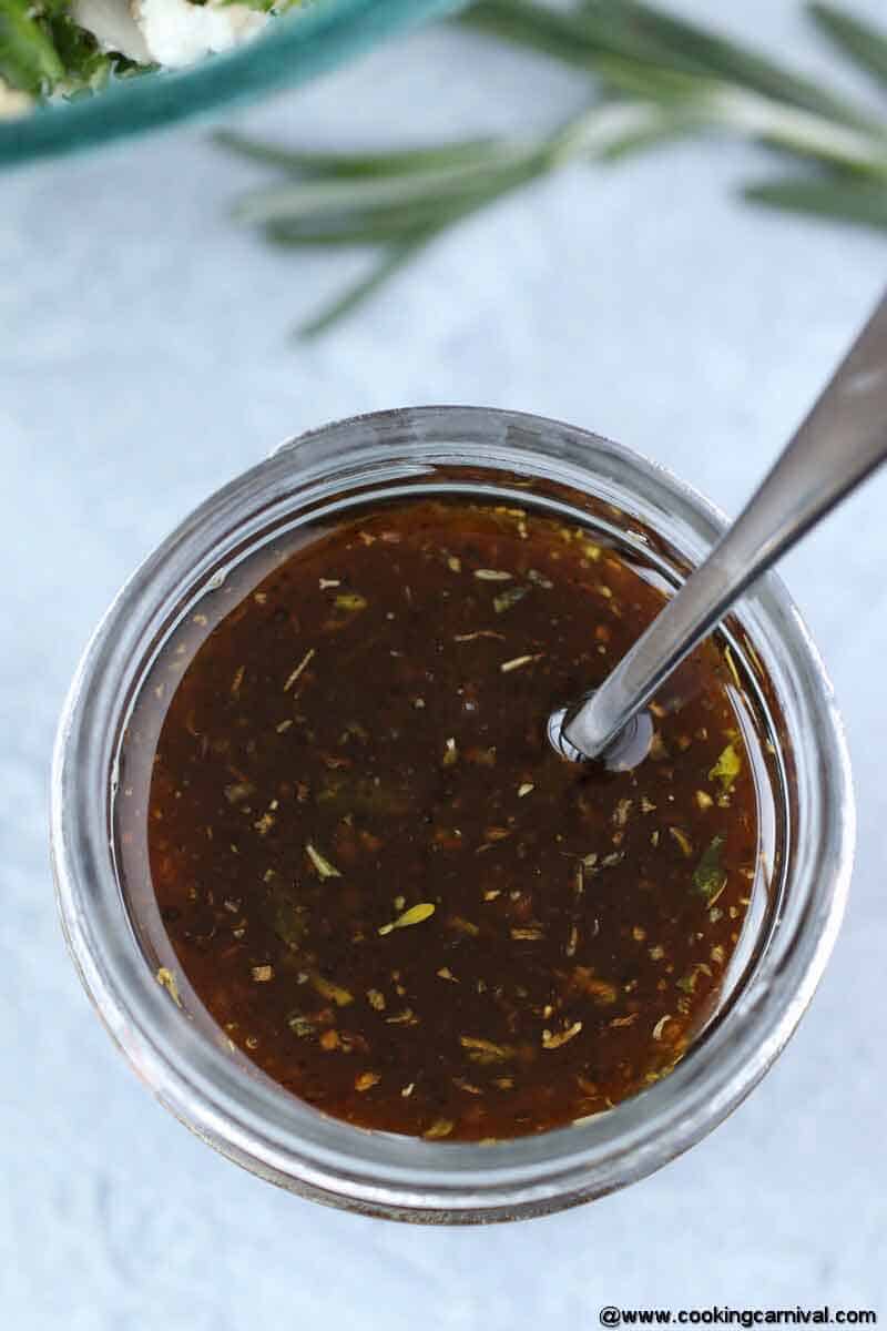 Balsamic Vinaigrette Dressing in a 4 oz mason jar with spoon on a gray tile