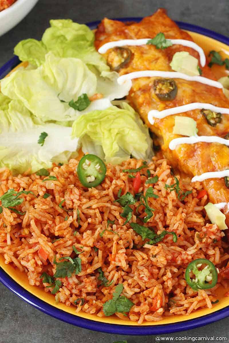 Mexican rice made in instant pot and served in yellow plate with enchilada and salad