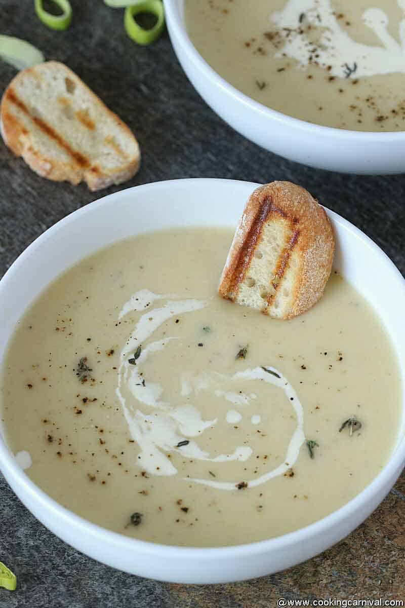 Instant Pot Potato leek Soup in a white bowl with bread