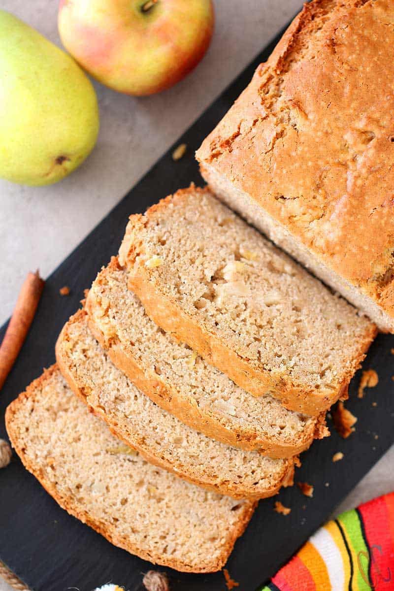 sliced Eggless Apple Pear Cinnamon Bread, served on a black board.