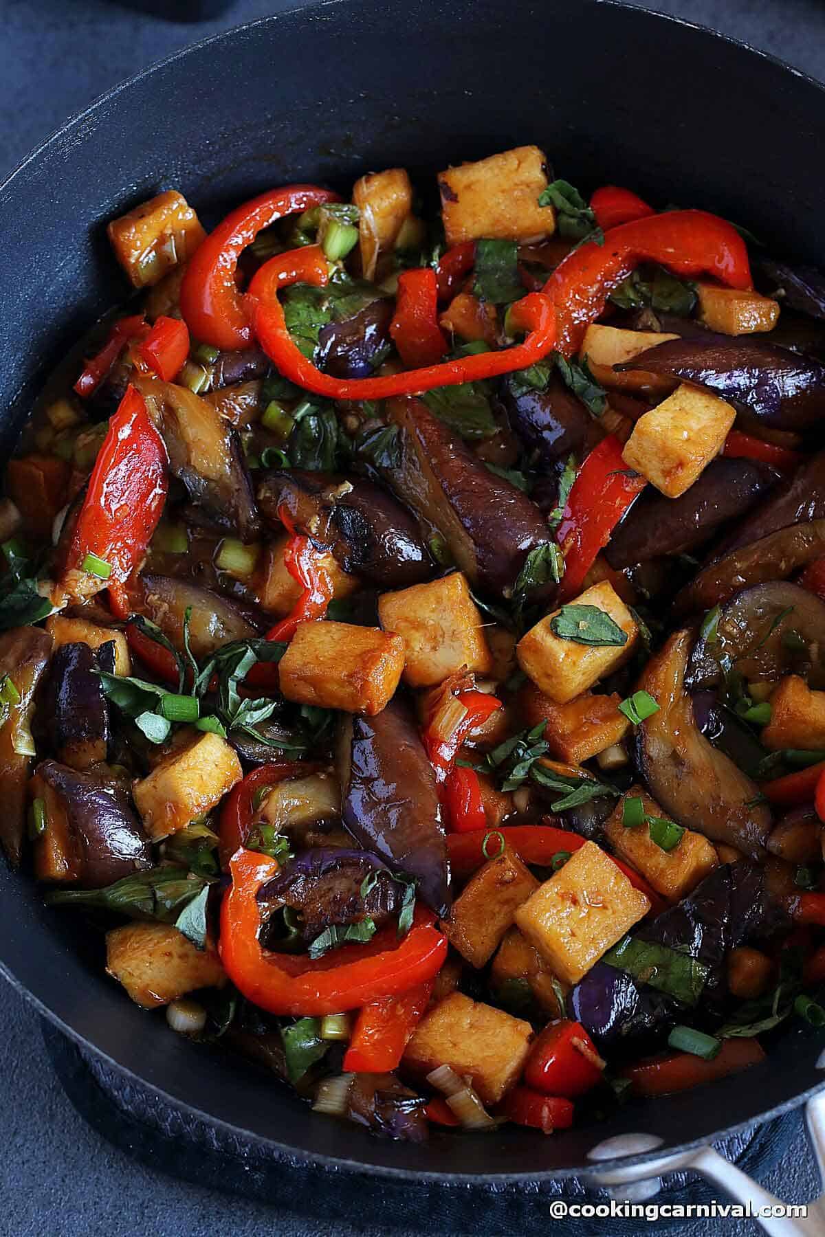 Eggplant tofu stir-fry in cast iron wok.