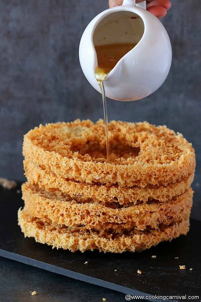 Pouring chasni (Sugar syrup) on stack of ghevar