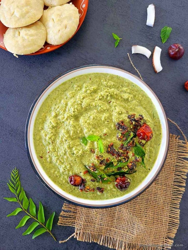 Green coconut chutney in a bowl, idli on the side