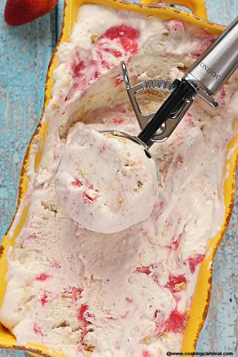 Homemade Strawberry Cheesecake Ice Cream - Creamy Ice cream Base with cream cheese and a Strawberry Sauce and Roughly Crushed Graham crackers swirled throughout. Its Dreamy, Creamy and one of the most delicious Homemade Ice cream I have made!