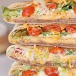 Vegetarian Homemade Crunchwrap Supreme Recipe - Refried beans, cheese sauce, crunchy tostadas, sour cream, chopped lettuce, diced tomatoes, Jalapenos and shredded cheese all wrapped inside a large burrito tortilla and then pan roasted until perfectly golden brown in color.