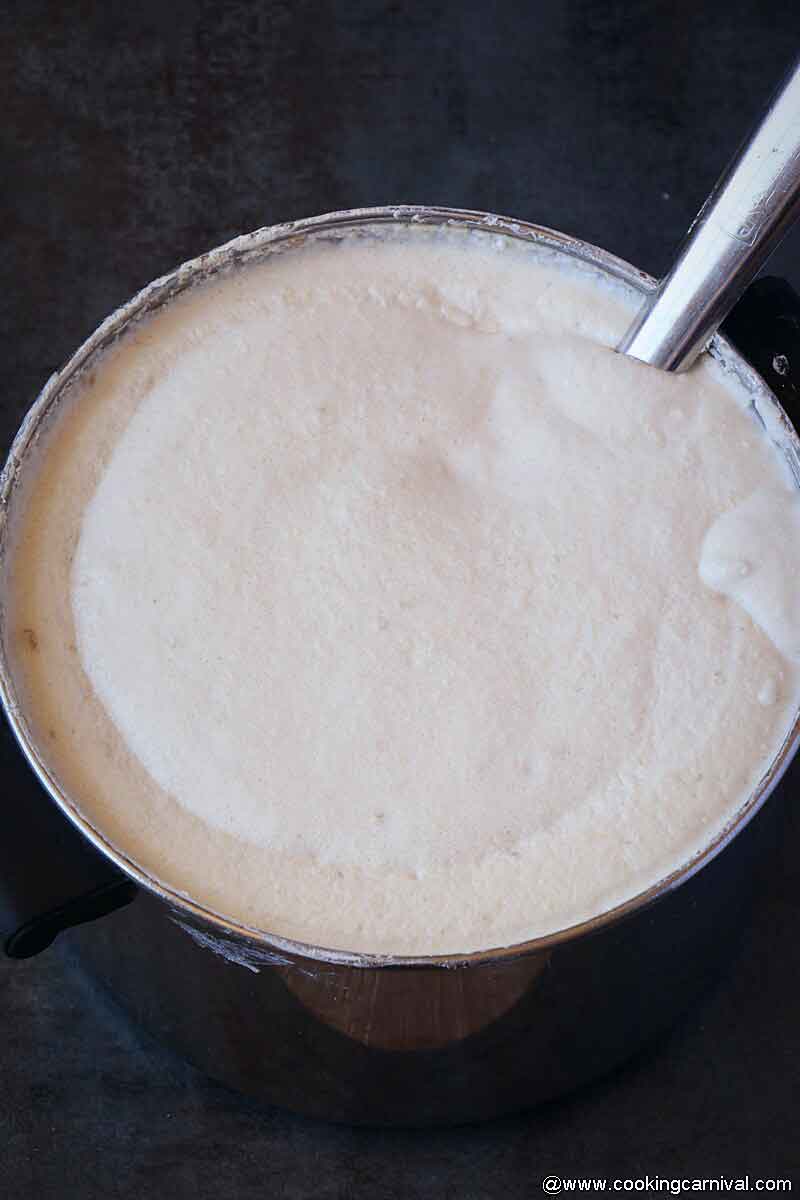 fermented Idli Dosa batter in steel pot with steel ladle