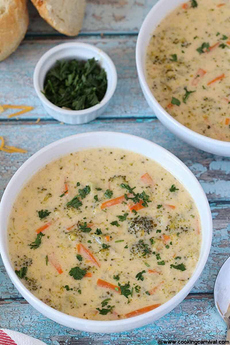 Instant pot broccoli cheddar soup in a white bowl, placed on a blue board