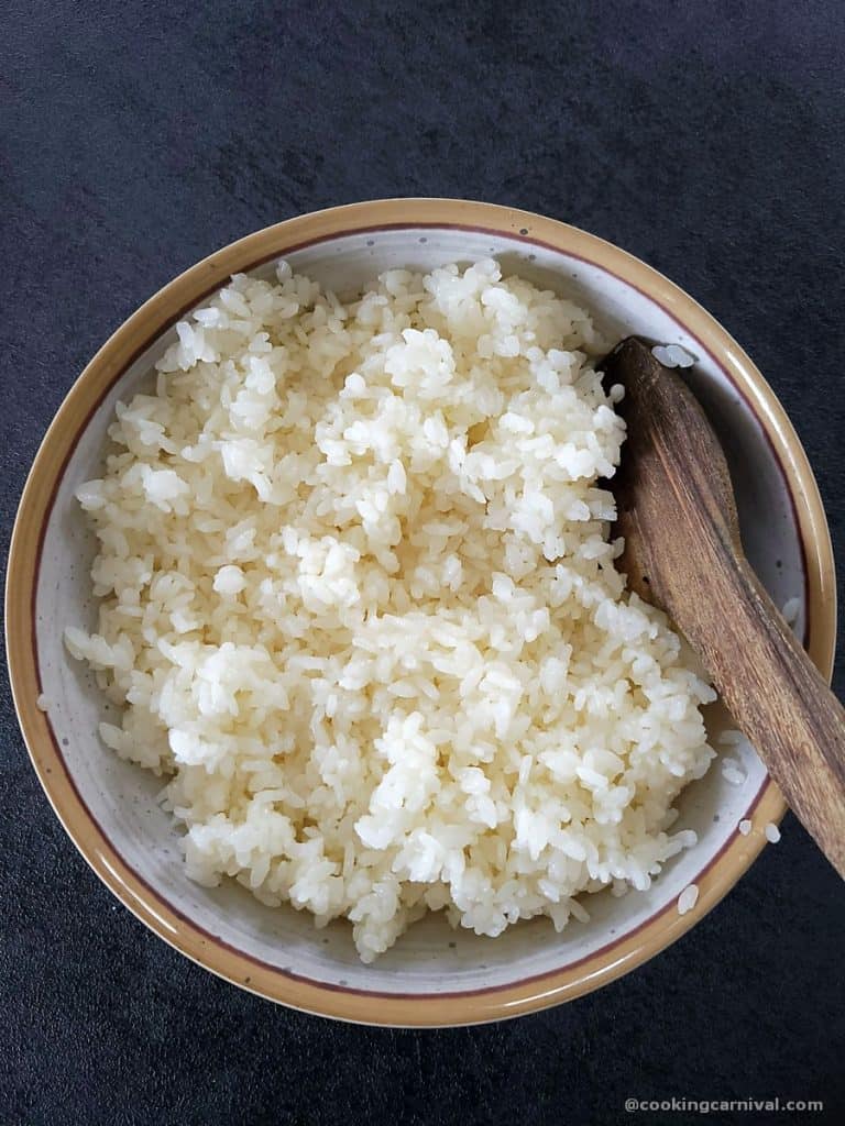 Instant pot sushi rice in a wooden bowl with wooden spatula