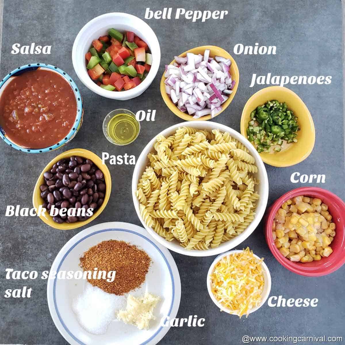 Pre-measured ingredients of pasta recipes on black tile