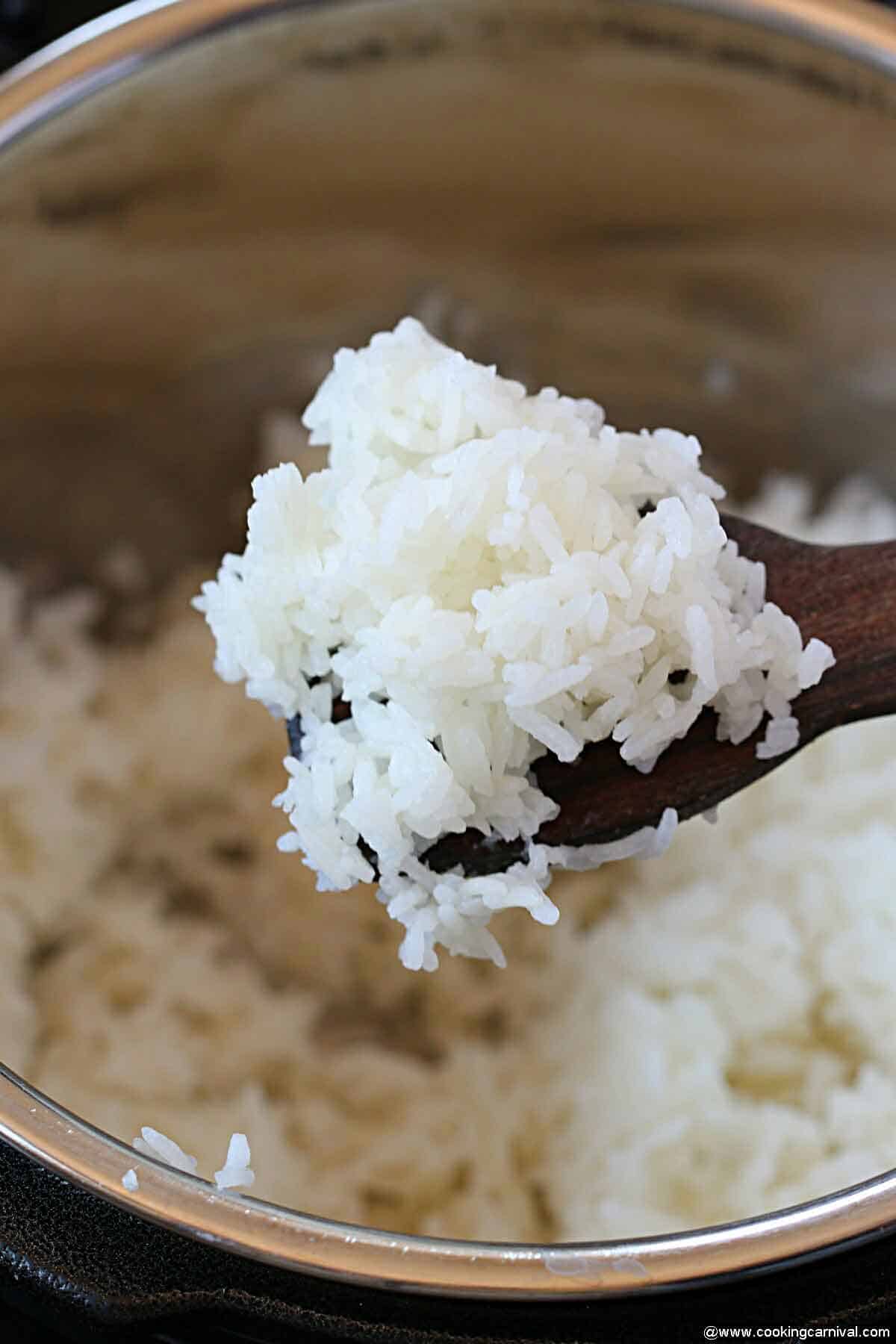 lifting rice with wooden spoon from the pot