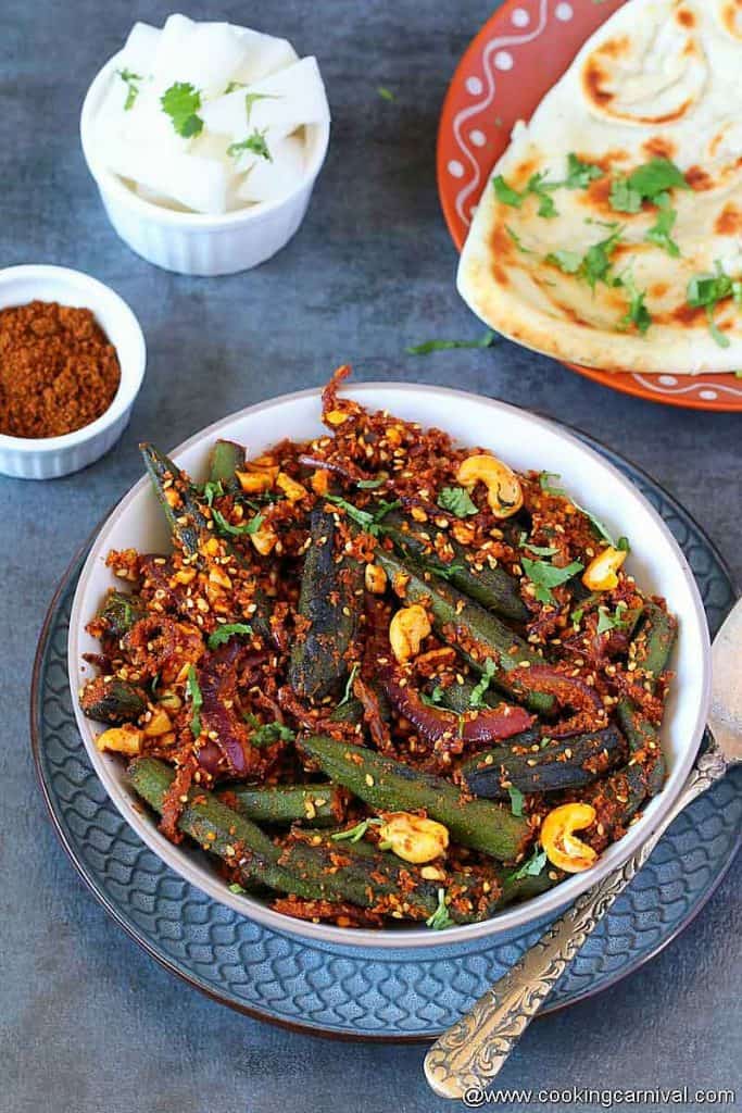 Bhindi Masala in a bowl, naan on the sides