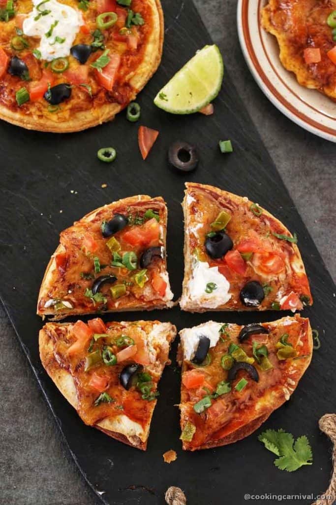 four mexican pizza slices on a black board