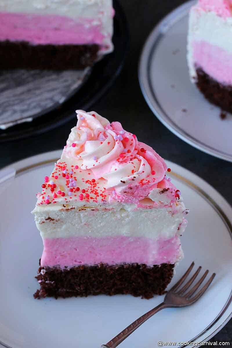 Neapolitan Ice Cream Cake piece on white plate with brown fork