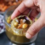 Holding pani puri with stuffing and teekha mitha pani in hand