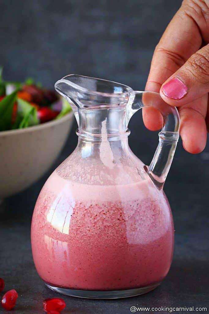 holding bottle of pomegranate vinaigrette 