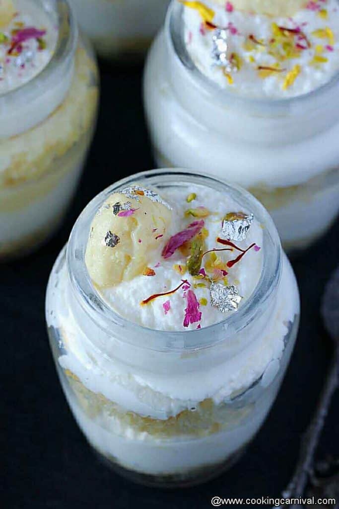 Decorated rasmalai cake jars with rose petals, saffron, chandi ka vark and crushed pistachios