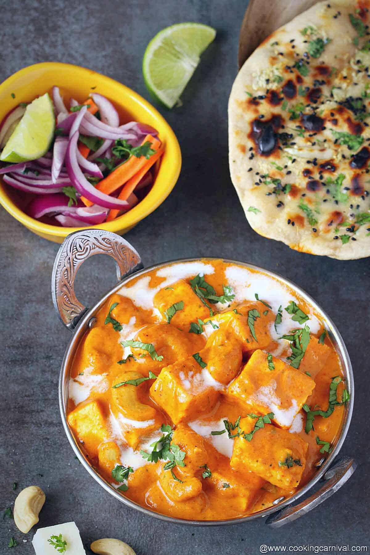 Final dish shot of paneer curry, tandoori roti and onion salad on the side