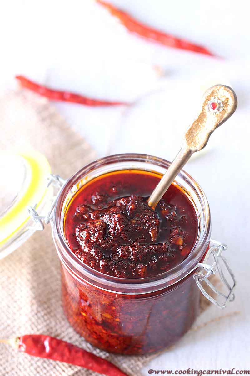 Schezwan Sauce with spoon in a glass bottle 