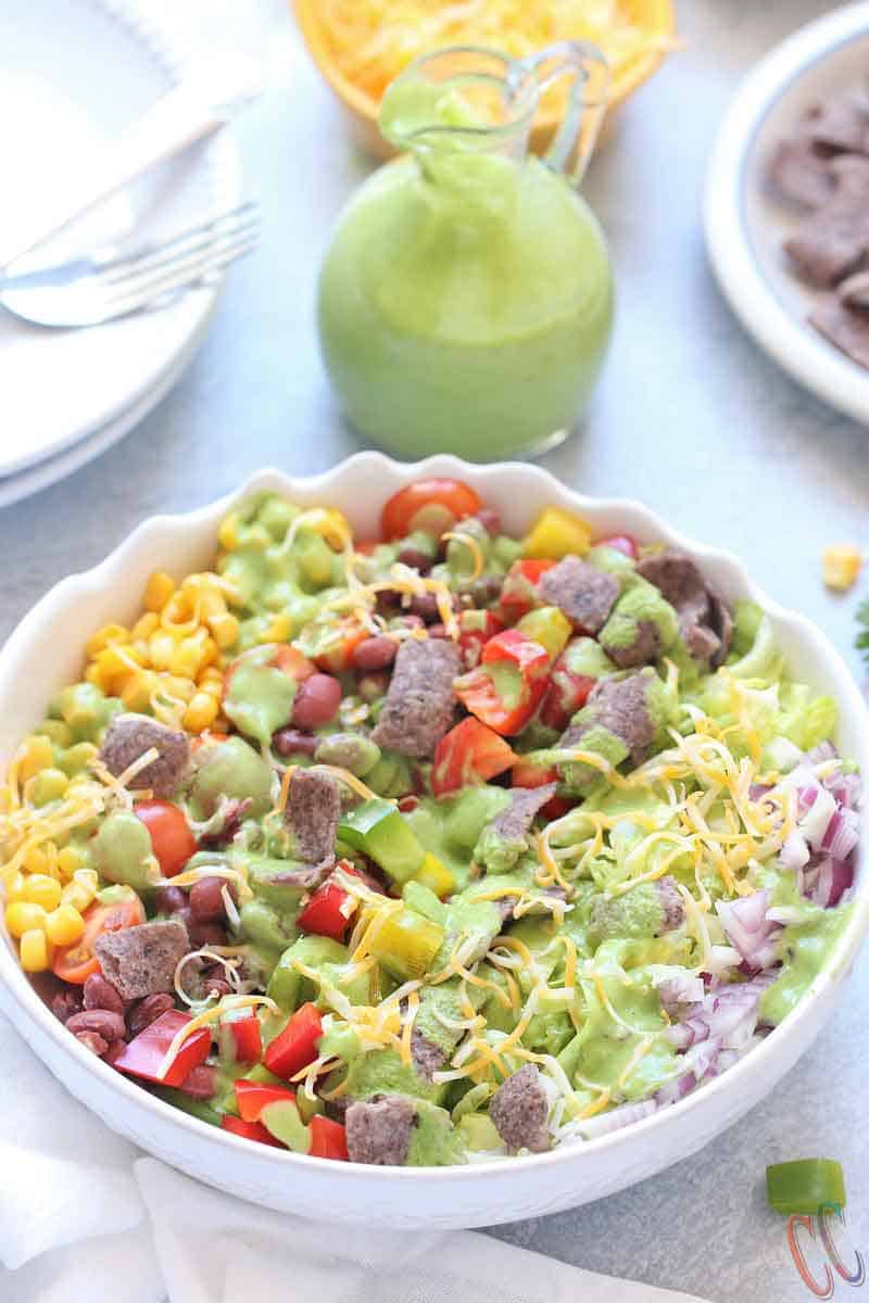 Southwest Salad - Bursting with small kidney beans, corn, bell peppers, cherry tomatoes, sweet corn, cheese, crispy lettuce, onions and bathed in Creamy-smooth Avocado Dressing, topped with blue corn tortilla chips. A super simple and classic salad that can be eaten in any season, be it summer, winter, spring or fall!