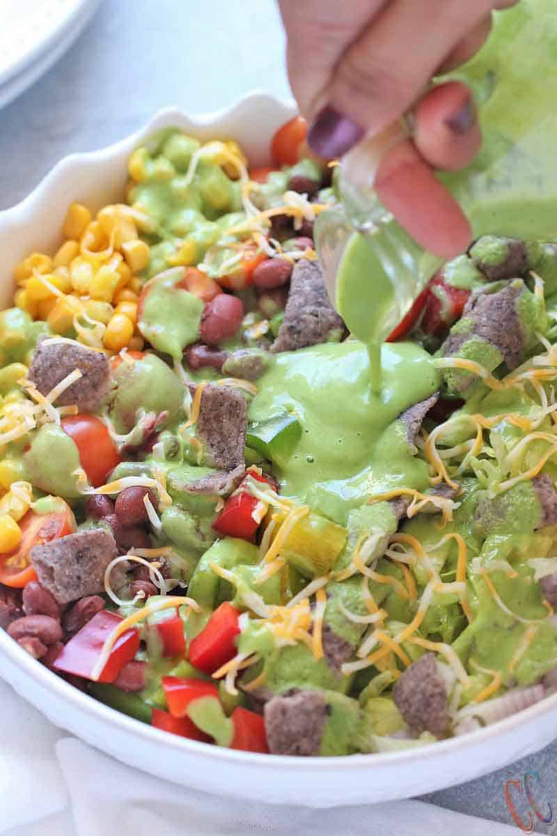 Southwest Salad - Bursting with small kidney beans, corn, bell peppers, cherry tomatoes, sweet corn, cheese, crispy lettuce, onions and bathed in Creamy-smooth Avocado Dressing, topped with blue corn tortilla chips. A super simple and classic salad that can be eaten in any season, be it summer, winter, spring or fall!