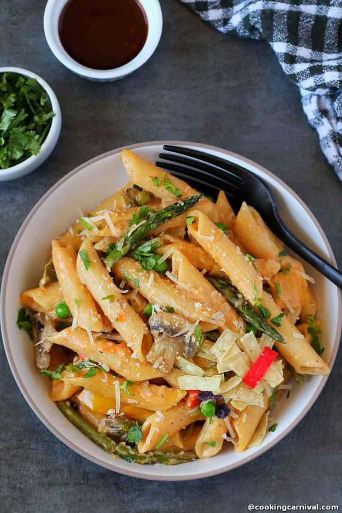 Spicy Chipotle Pasta made in instant pot and served in white bowl, fork, cilantro, adobo sauce on the side