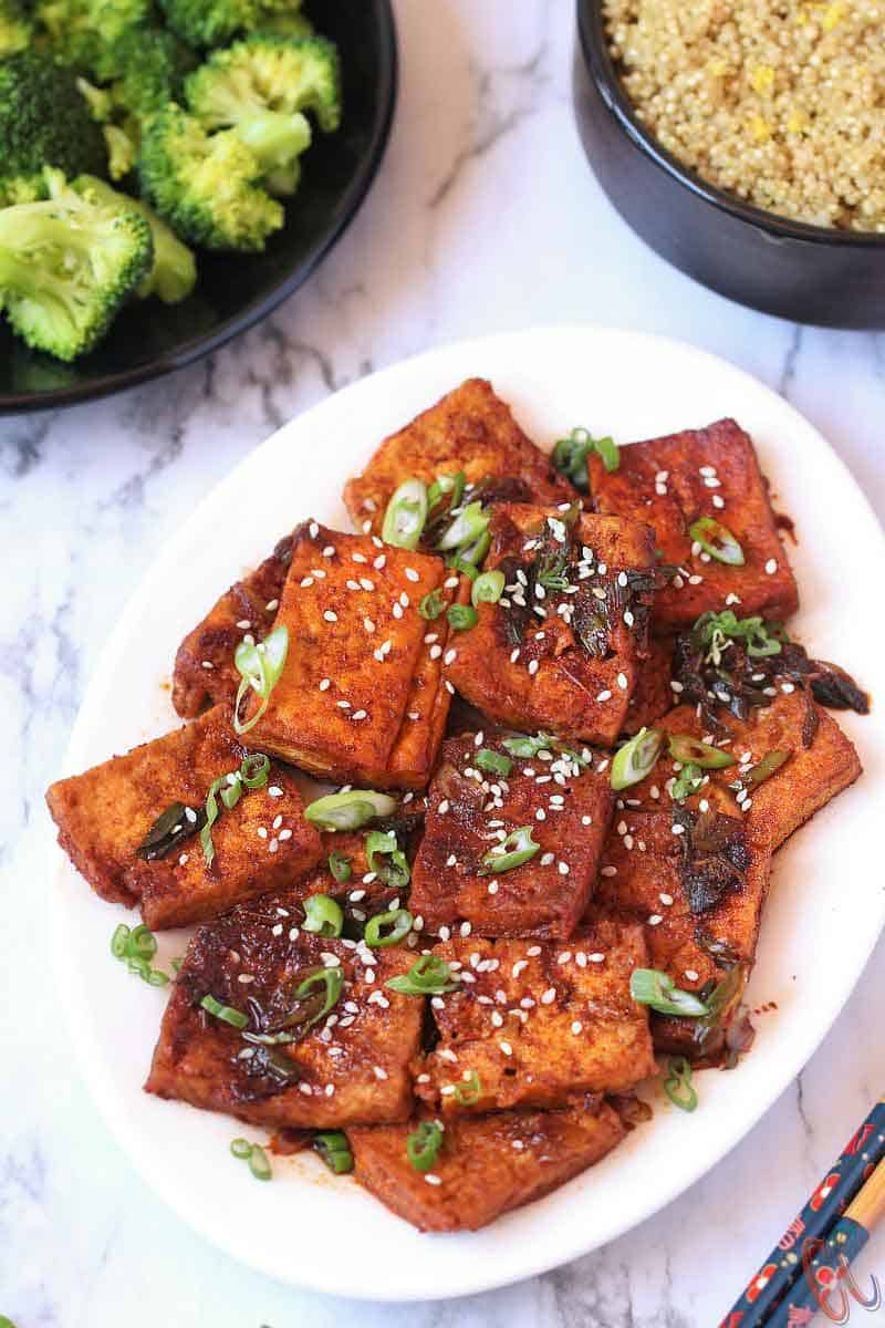 Spicy Braised Tofu / Dubu Jorim - A traditional Korean dish made with pan fried tofu, braised in a savory-spicy sauce with green onions and garlic. It's juicy, a little spicy and delicious. It is the best Korean Side Dish served with Rice, Noodles or with Coconut Quinoa.