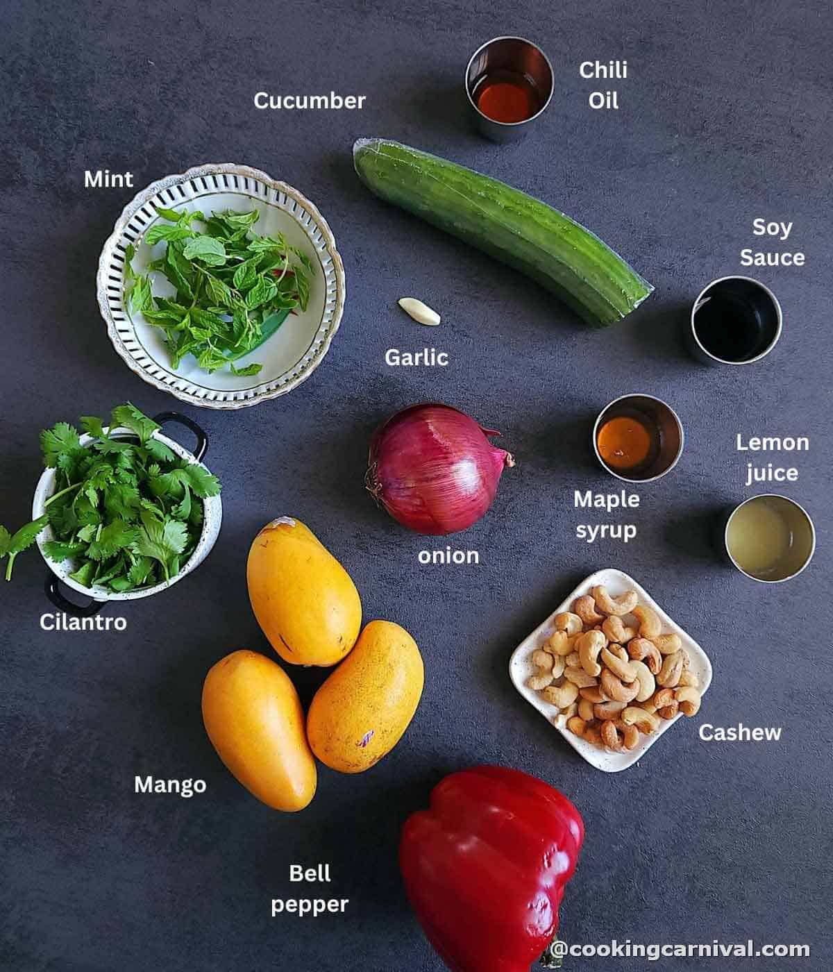 premeasured ingredients of spicy mango salad in a black board.