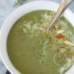 Spinach soup in white bowl with spoon