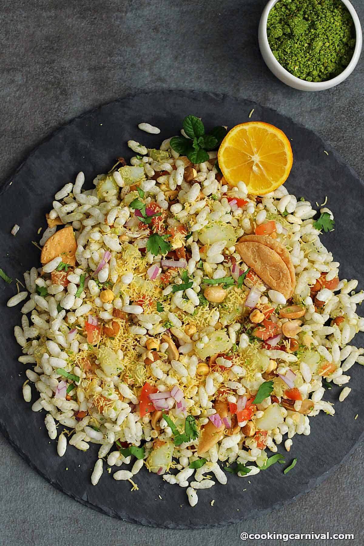 Sukha bhel in a cheese board, lemon on the side.