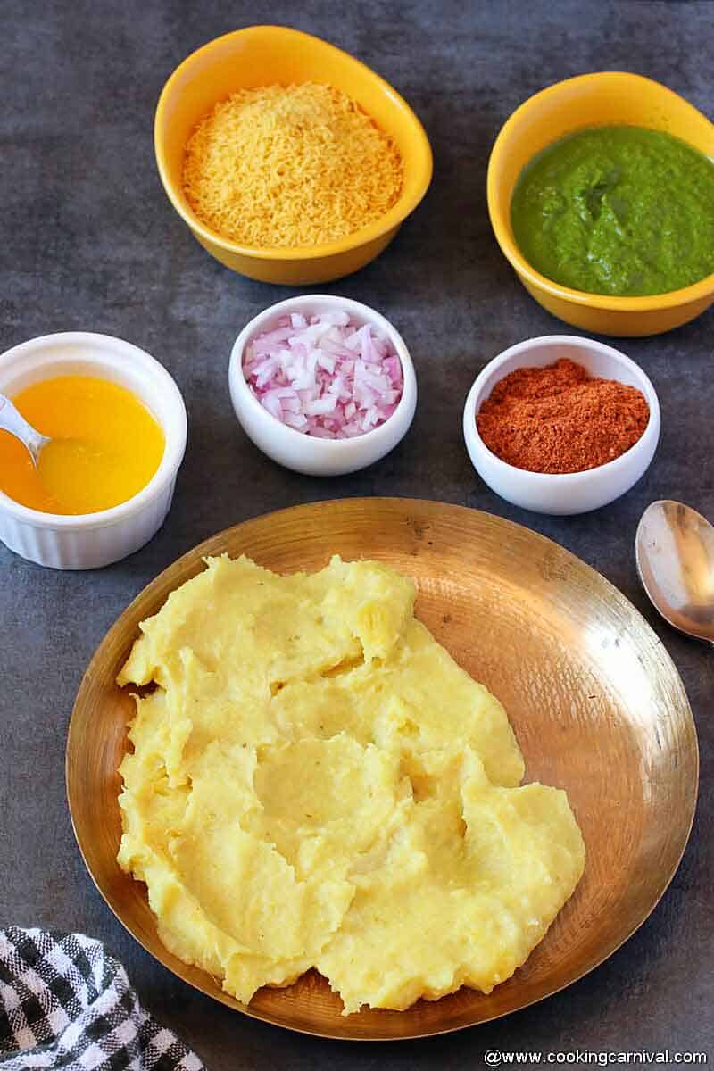 Locho served in kansa plate, butter, onion, sev, masala, green chutney on the sides