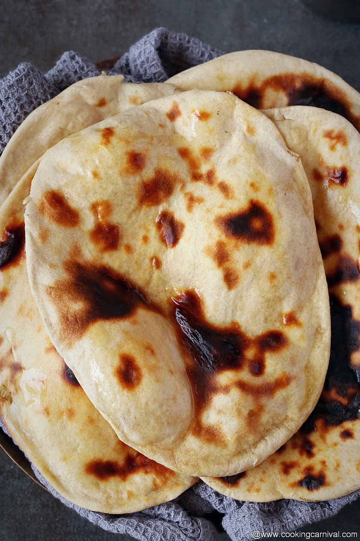 Stack of tandoori roti on black tile