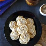 Thandai Melting Moment Butter Cookies in a black plate, chai and books on the side