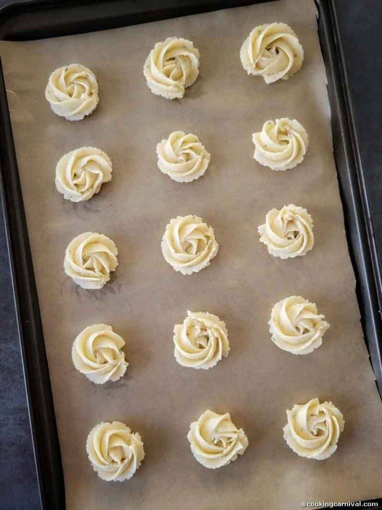 Piped butter cookies on a baking tray