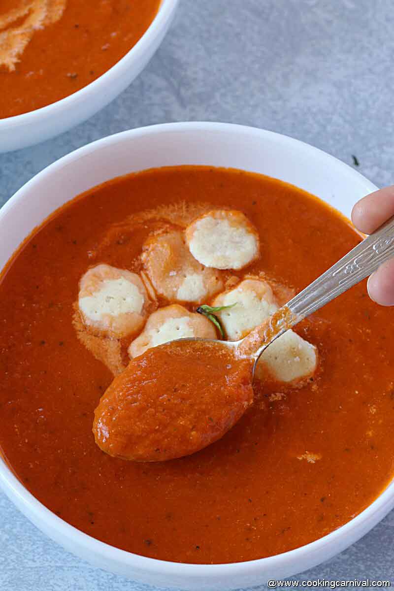 spooning tomato basil soup