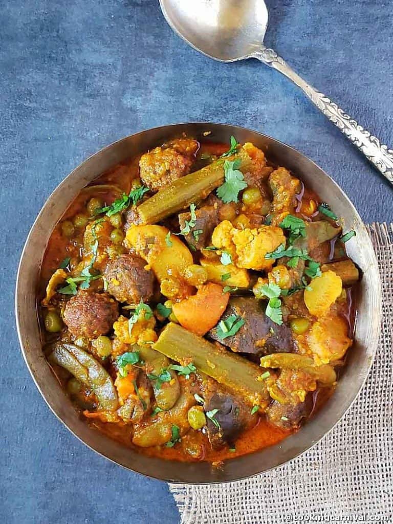 Undhiyu in a kansa bowl, spoon on the side