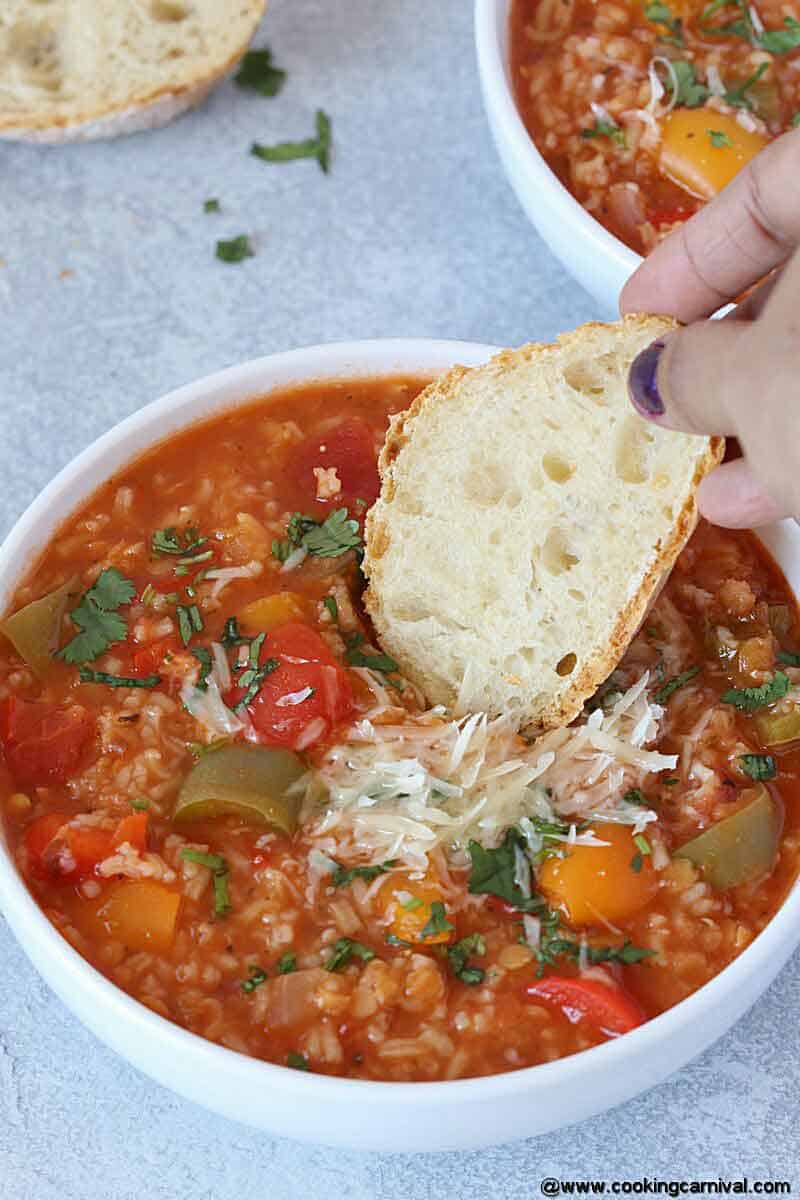 dipping crusty bread in vegetarian instant pot stuffed pepper soup