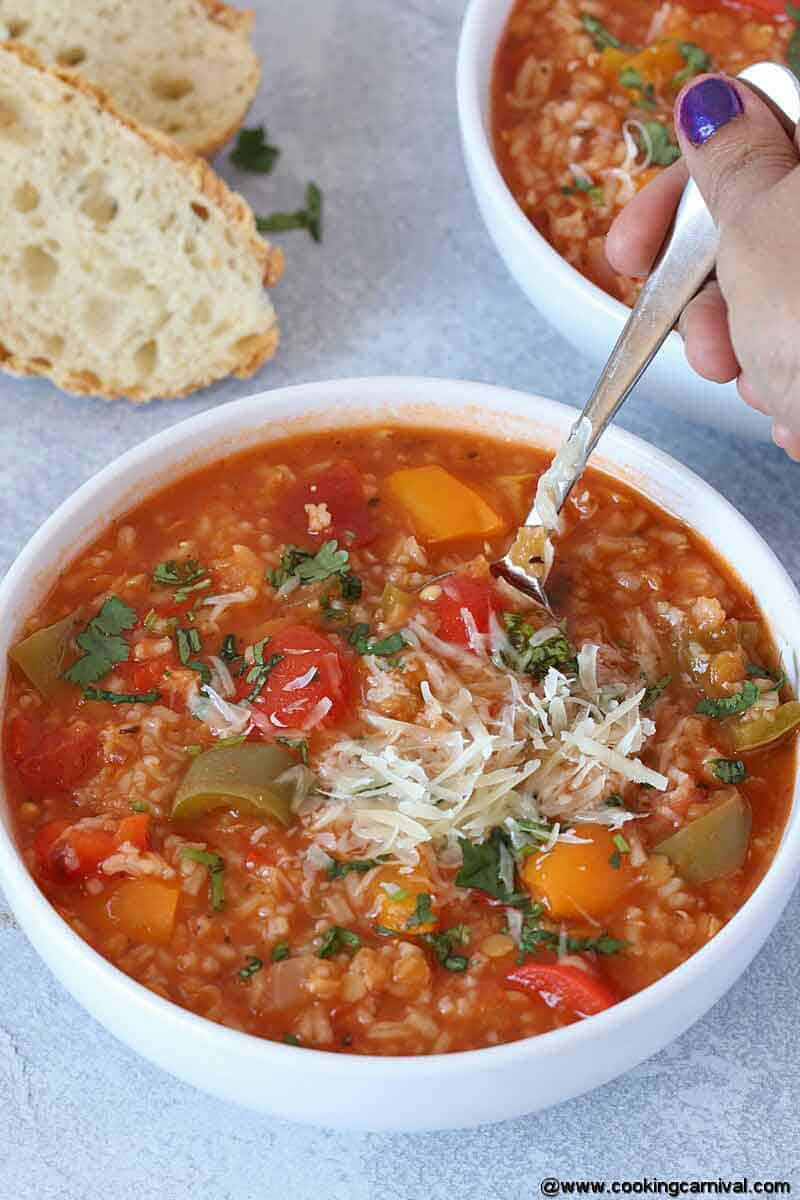 spooning vegetarian instant pot stuffed pepper soup from white bowl