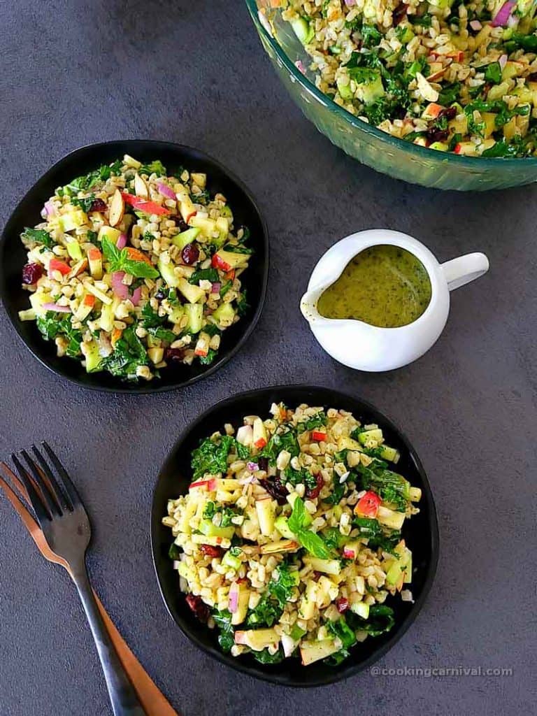 Wheat berry salad in black plates, mint dressing on the side