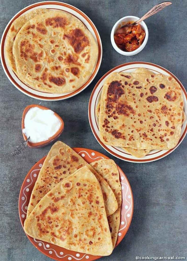 Triangle, square and round whole wheat paratha on black tile